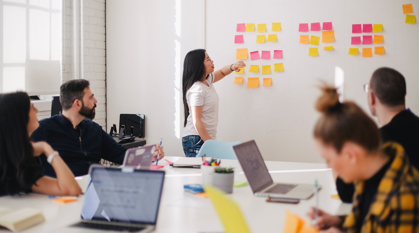 A marketing team mapping out a strategy with notes on a wall