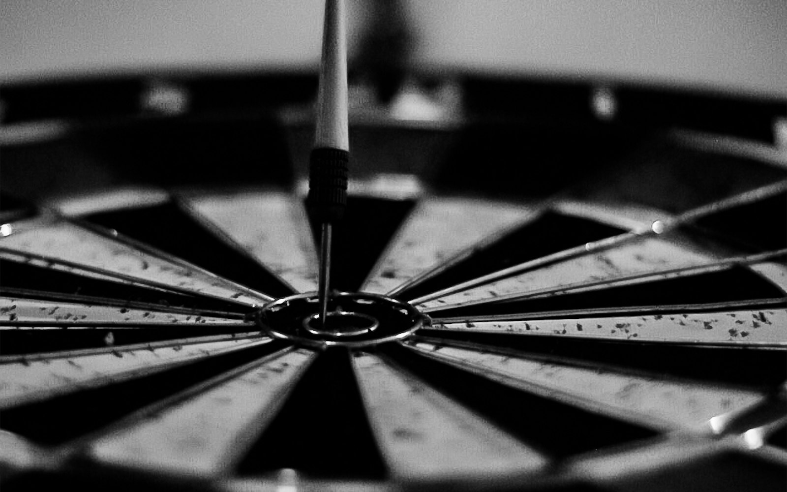 A dart landing in the centre bullseye of a dartboard